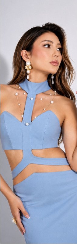 Mujer con aretes y collares de perlas sobre vestido azul