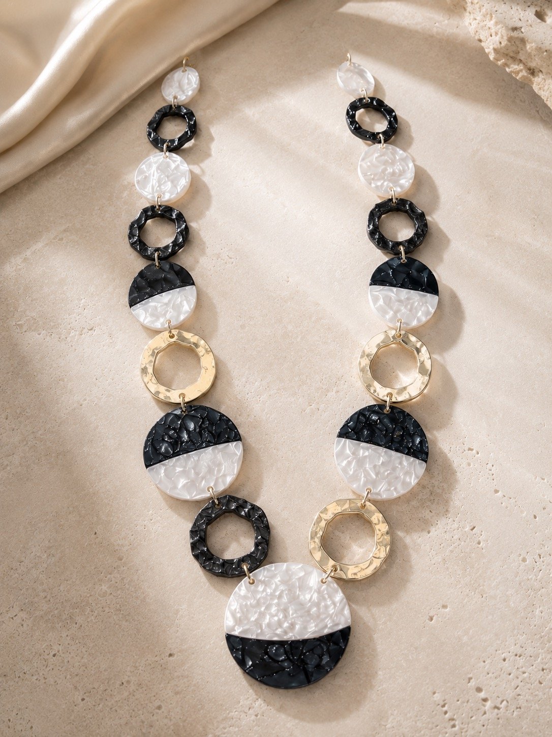 Collar largo de discos blancos y negros con aros dorados